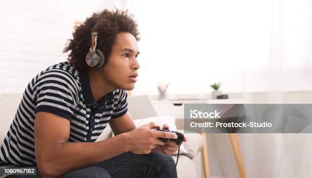 Concentrated Teenager Playing Video Games With Joystick Stock Photo - Download Image Now