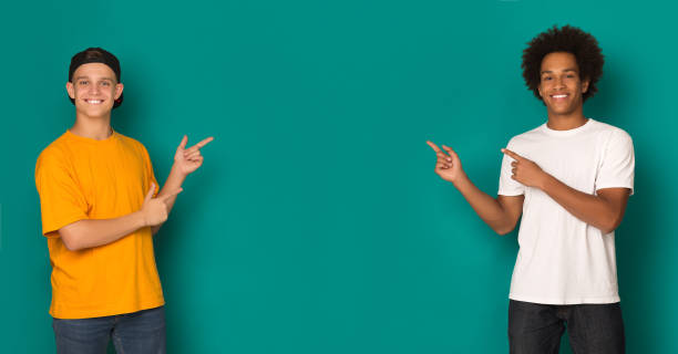 istock Friendly teen boys pointing on copy space 1080967270