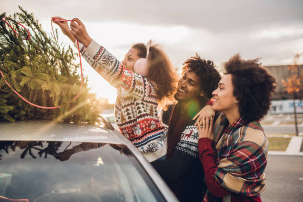 istock Merry family putting Christmas tree on a car 1080982334