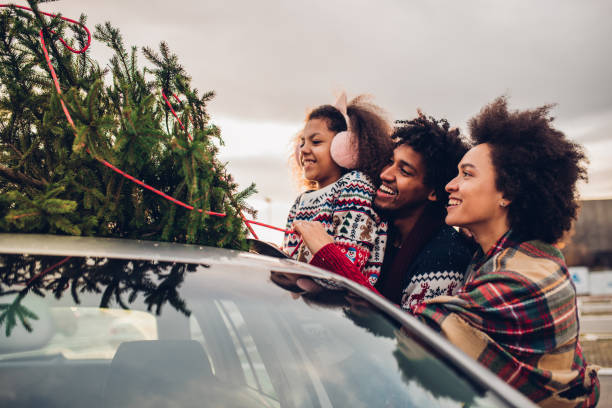 istock Parents with a child putting Christmas tree on a car 1080983530