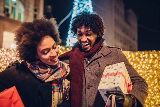 istock Young couple looking inside Christmas shopping bag 1080992304