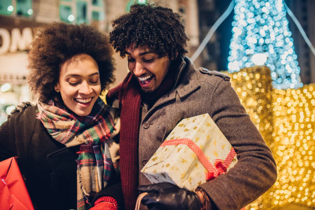 istock Laughing young couple looking inside Christmas shopping bag 1080992398