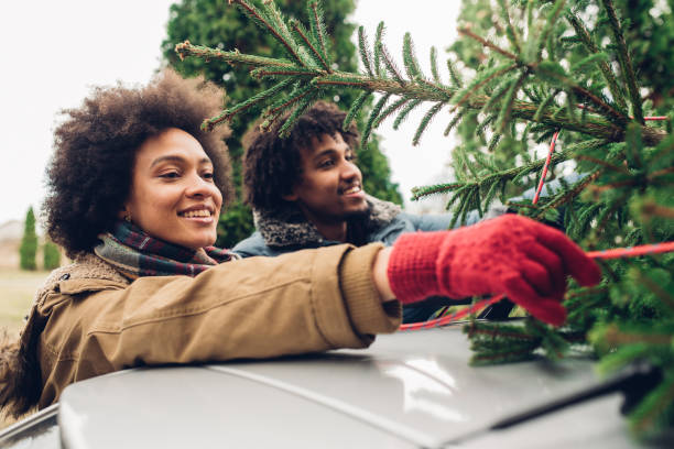 istock Smiling woman tying Christmas tree 1081001092