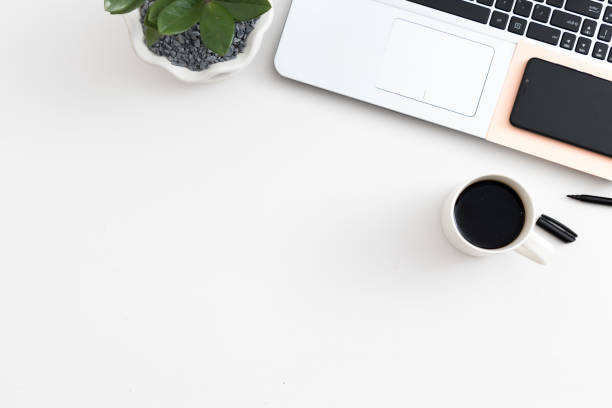 istock White office desk with laptop office plant and notebook and mobile phone 1081010932