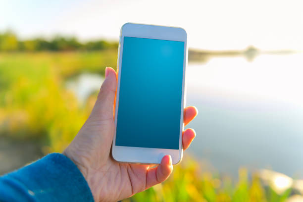 istock Hand holding mobile phone at natural backgrouds 1081012280