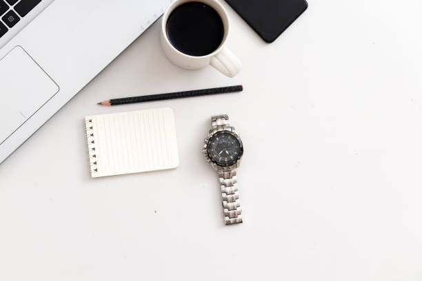 White office desk with laptop, watch, key, office plant. Top view with copy space, flat lay