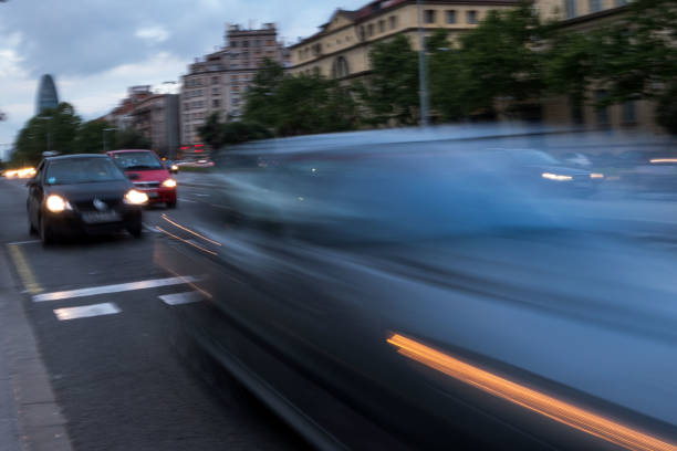 Street of a European city, full of cars parked on the side of the road on a summer day. o