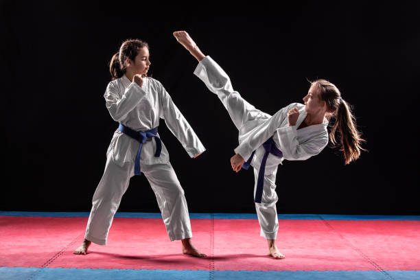 dos niñas en combate de taekwondo - taekwondo fotografías e imágenes de stock