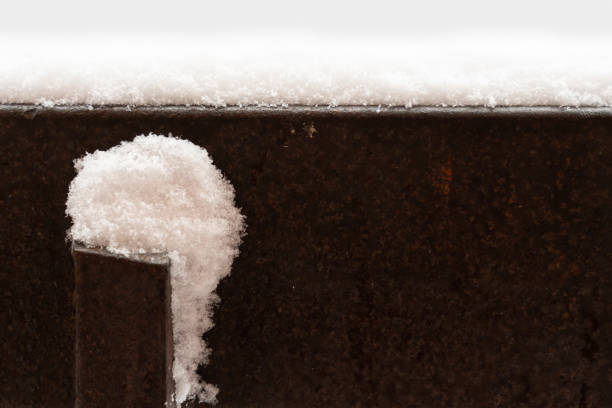 the snow on the surface of an old rusty metal structure as a background
