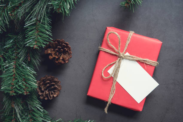 istock Christmas gift box with note card and tree branch decor on marble background. 1081046812