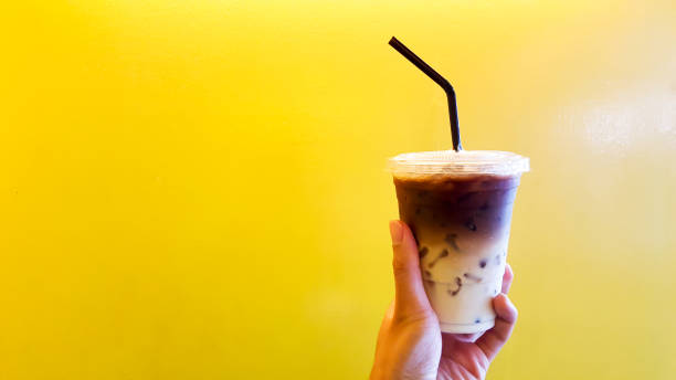 istock Ice milk tea hand in the yellow background 1081046930