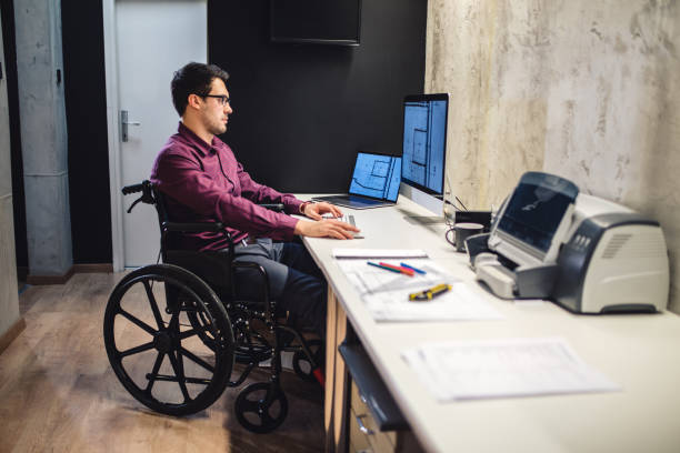 arquiteto moderno em uma cadeira de rodas a trabalhar no escritório - computer engineer blueprint architect - fotografias e filmes do acervo
