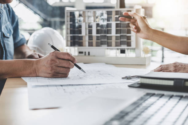 istock Hands of architect or engineer working on blueprint meeting for project working with partner on model building and engineering tools in working site, Construction and structure concept 1081061812