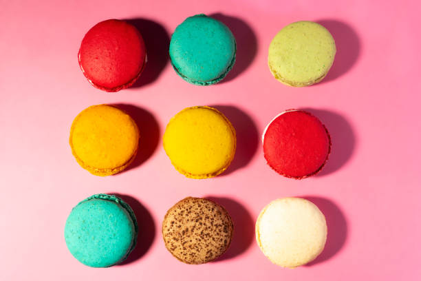 istock Grid pattern of vibrant multi-coloured handmade Macaroons against a pink background from above. 1081062074