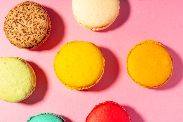 istock pattern of vibrant multi-coloured handmade Macaroons against a pink background from above. 1081062080