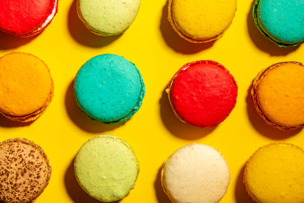 istock Grid pattern of vibrant multi-coloured handmade Macaroons against a yellow background from above. 1081062096