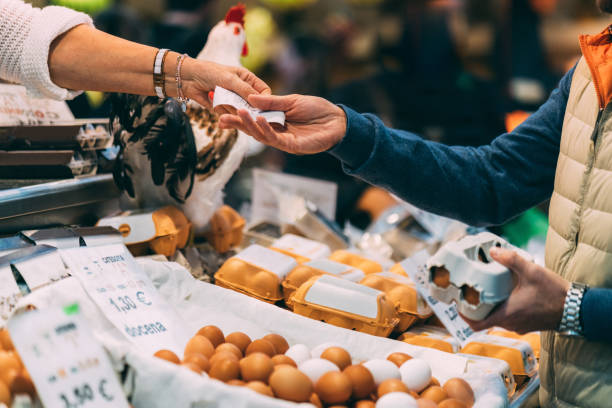 cliente comprar huevos orgánicos en el mercado - market market stall shopping people fotografías e imágenes de stock