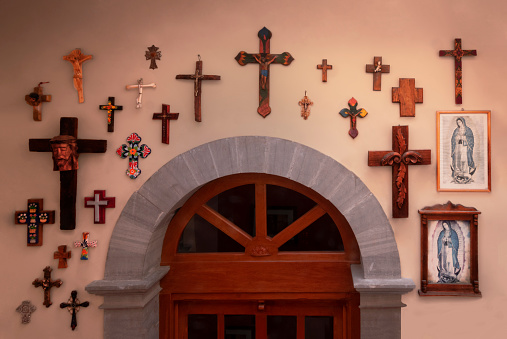 Group of crosses on wall over wooden door