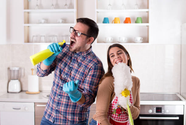 happy couple singing and doing chores - spring cleaning women cleaning dancing imagens e fotografias de stock