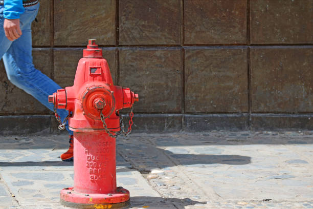 istock Red fire extinguisher on the footpath with a man walking behind, Puno old town, Peru, South America 1081079560