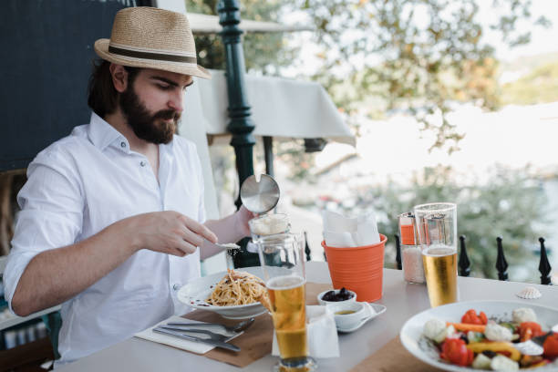istock Tourist eating spaghetti and drinking beer in a restaurant in Greece 1081088672