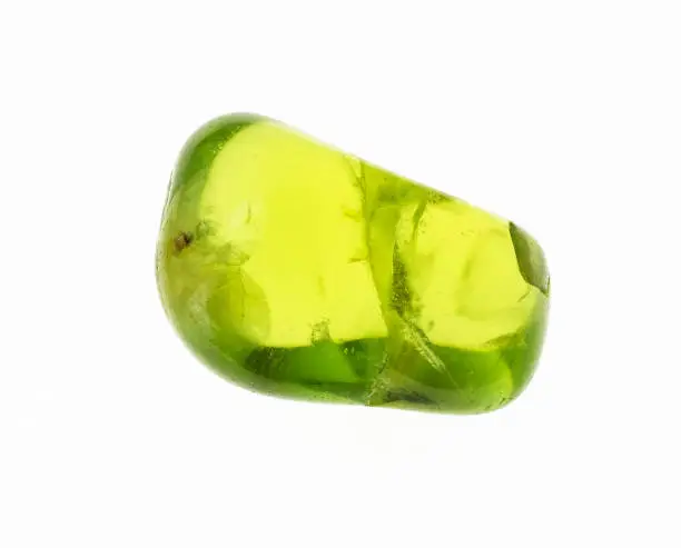 macro photography of natural mineral from geological collection - tumbled olivine (chrysolite, peridot) gem stone on white background