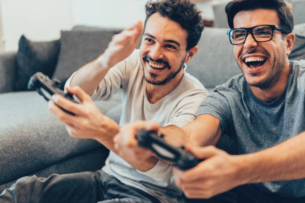 Excited friends playing video games Excited friends playing video games at home brother stock pictures, royalty-free photos & images