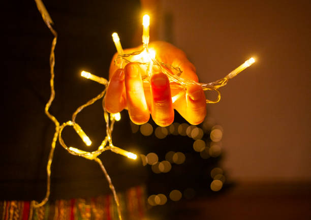 istock christmas lights in hands of a woman decorating a tree 1081099366