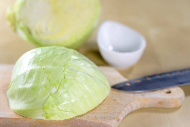 istock Fresh white cabbage cut into strips on the kitchen table. Vegetables prepared for salad. Light background. 1081099374