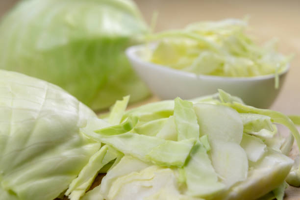 istock Fresh white cabbage cut into strips on the kitchen table. Vegetables prepared for salad. Light background. 1081100186