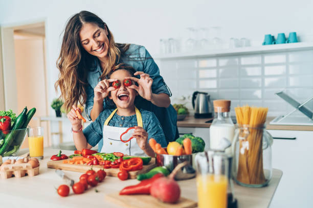 Happy time in the kitchen Playful mother and daughter in the kitchen family with one child stock pictures, royalty-free photos & images