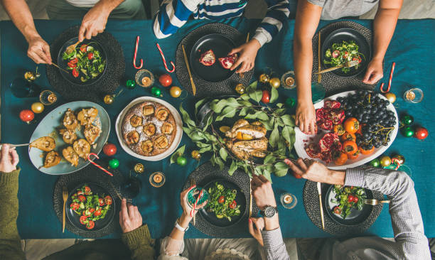 istock Human hands holding glasses with drinks and eating at Christmas 1081109264