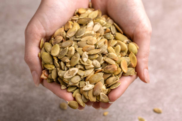 istock Fresh pumpkin seeds in woman's hands 1081113510