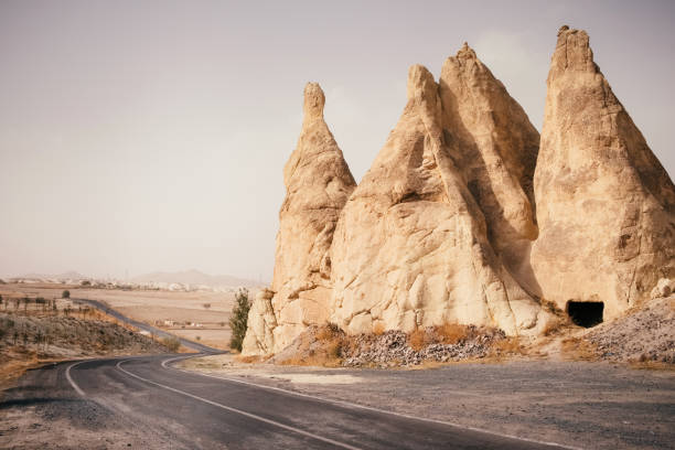Beautiful empty road through dry sand desert and canyon landscape, Cappadocia Goreme village, Turkey
