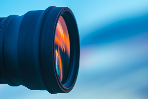 The camera lens on the background of a blue sky. close up view