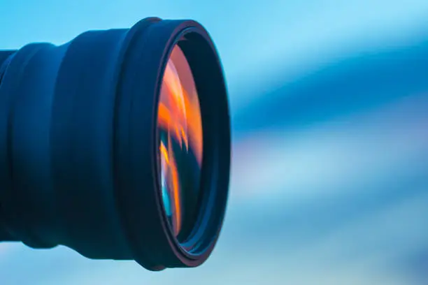 Photo of The camera lens on the background of a blue sky. close up view