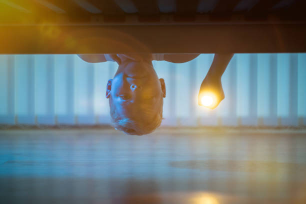 the little boy with a flashlight under bed. night time - happy kid flash imagens e fotografias de stock