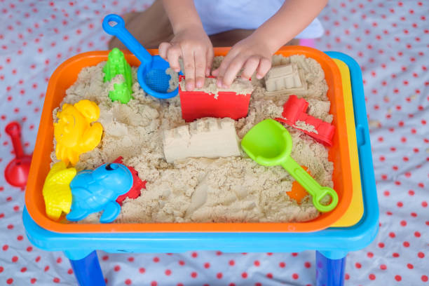 vue de dessus bouchent de petite asiatique 2 - 3 ans bambin garçon jouant avec le sable cinétique à la maison - sandbox child human hand sand photos et images de collection