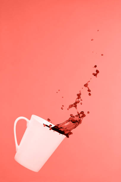 istock Levitating coffee mug with splashes. Coffee concept. Minimal art trend. Solid pink background . Living coral theme - color of the year 2019 1081156148