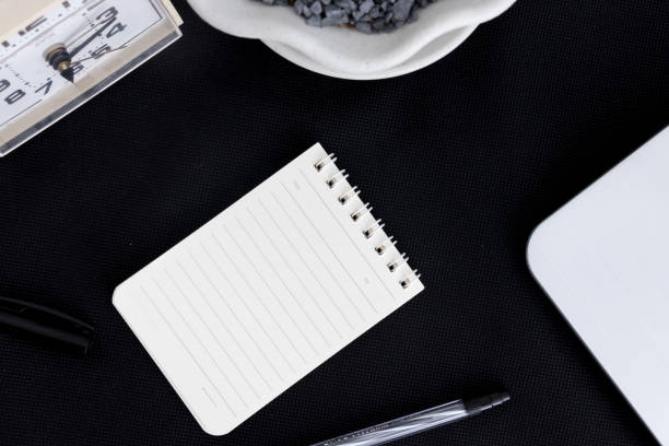 istock Black office desk with notebook and pen office plant 1081172752