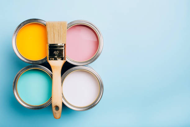 istock Brush with wooden handle on open cans on blue pastel background. 1081176514