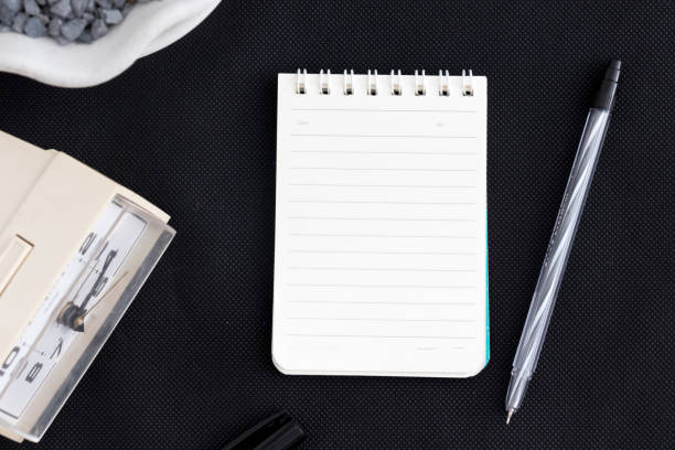 istock Black office desk with notebook and pen office plant 1081178462