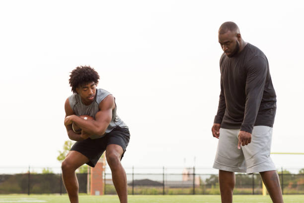istock American Football coach training a young athlete. 1081184818