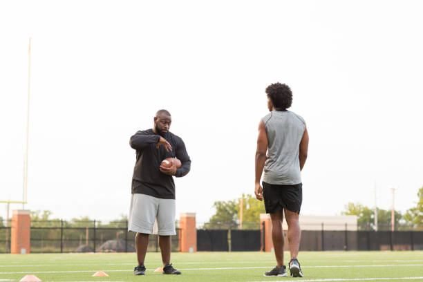 istock American Football coach training a young athlete. 1081184830