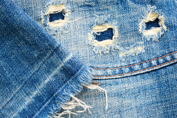 istock Denim fabric texture with holes and threads 1081188688