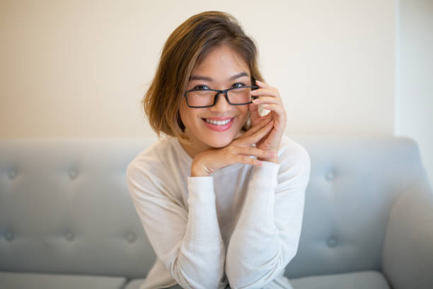 istock Smiling pretty young lady sitting on sofa and posing at camera 1081190984
