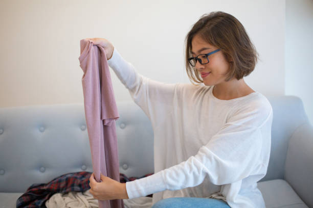 istock Smiling pretty young woman sorting laundry at home 1081191000