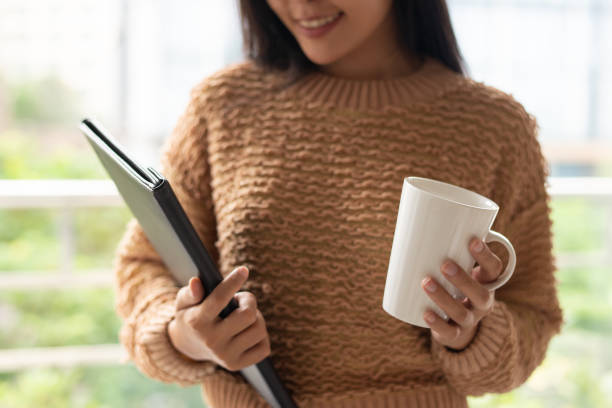 istock Content confident businesswoman holding mug and folder 1081198616
