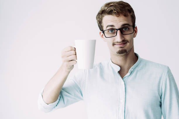 istock Content handsome man showing mug and frowning forehead 1081201600