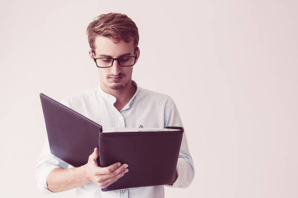istock Concentrated man in glasses filling form and holding folder 1081201606